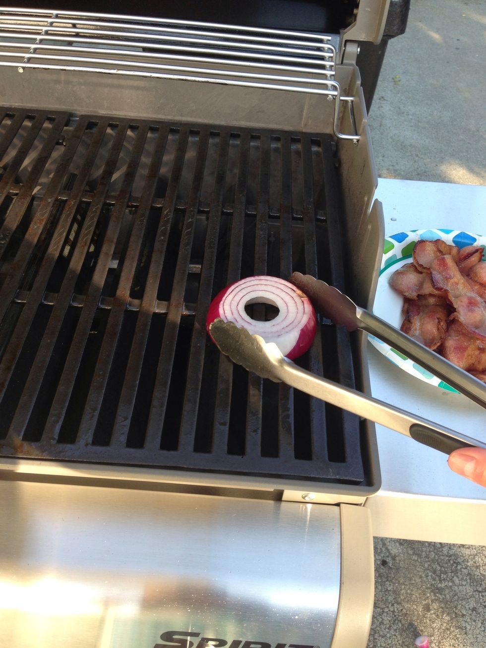 Take the bacon off the grill and rub the onion over the cooking surface of the grill. .