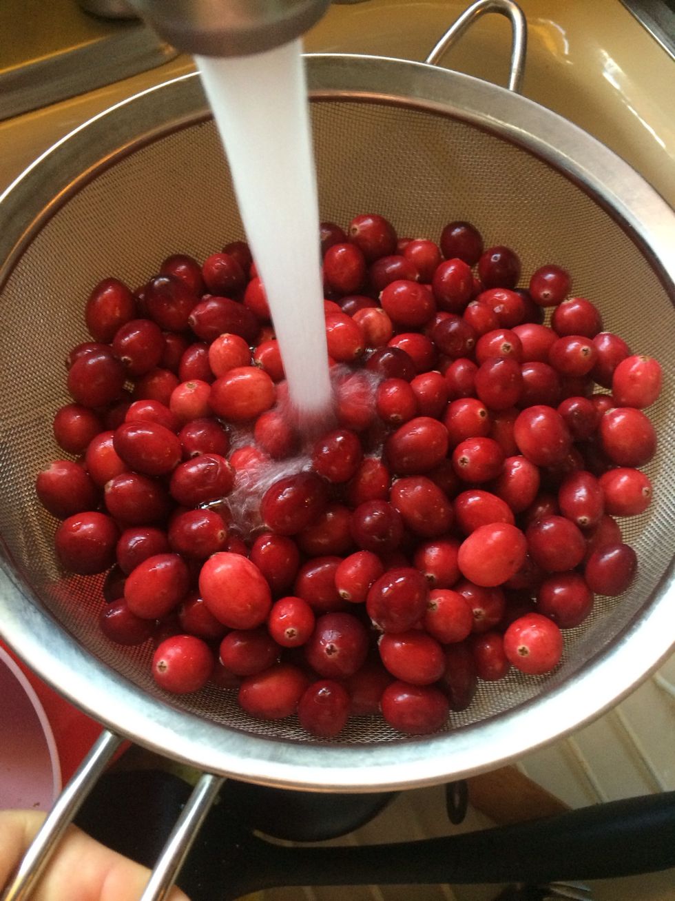 Take the bag of cranberries and give it a quick rinse under running water. Picking out any cranberries that are damaged and discarding it.
