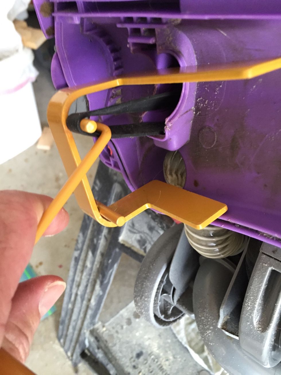 Take the belt tool and place it on top of the drive belt. Using the belt tool hook pull hard and place the drive belt on the top post of the tool