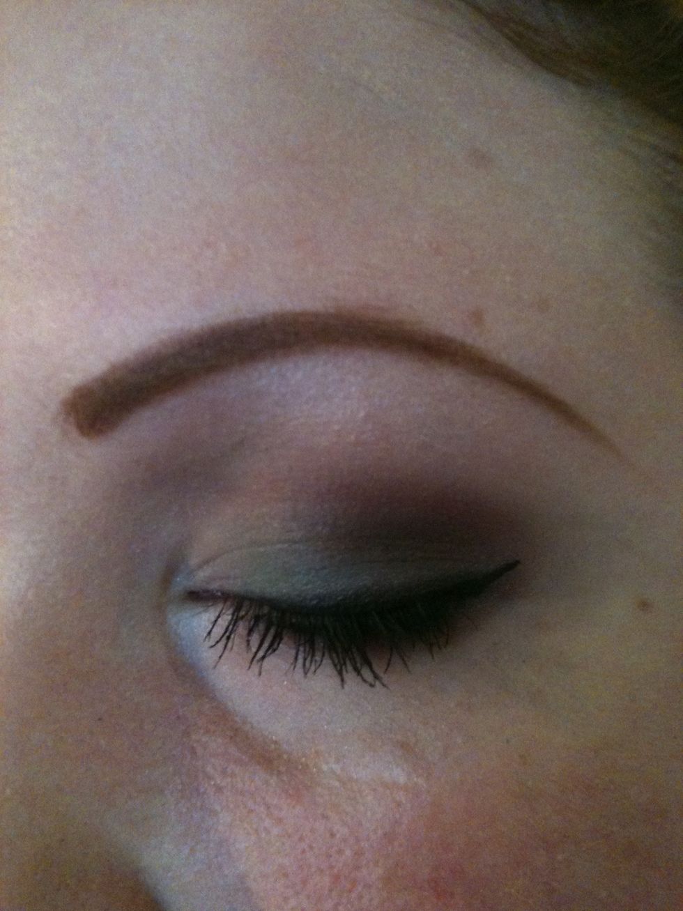 Take the black eyeshadow and soften the line at the top so it isn't so harsh. Add a little highlighter to your brow bone and inner corner of your eye