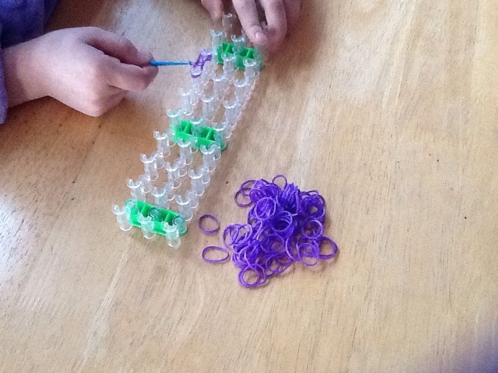 Take the bottom loom band and pull it over the peg.