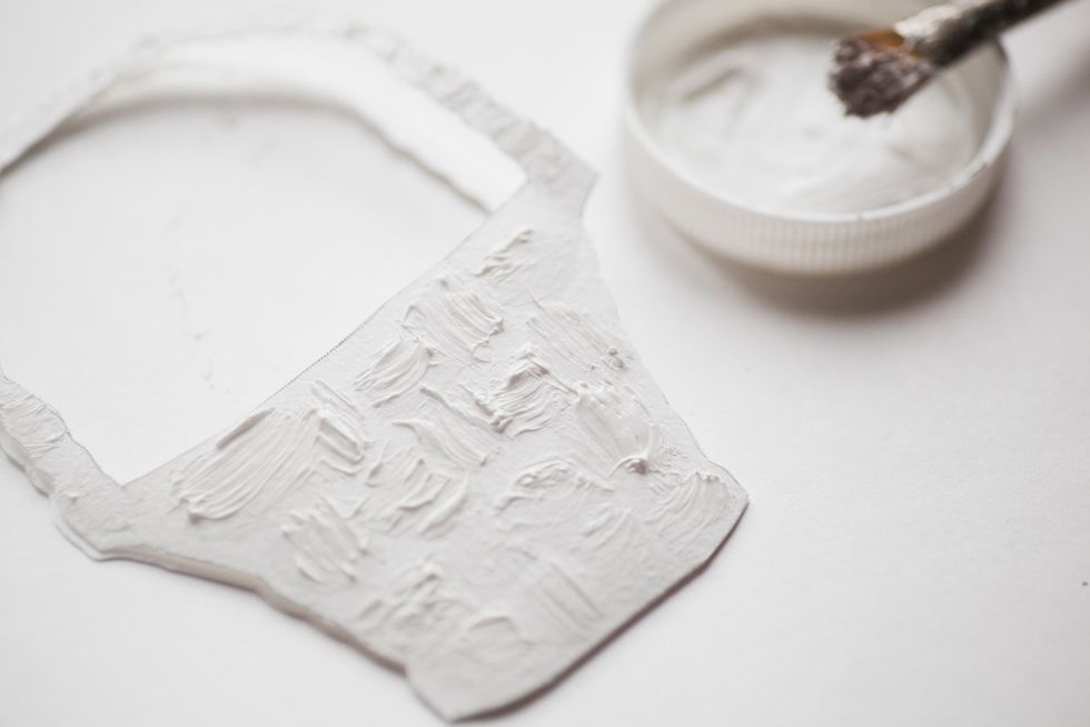 Take the brush, dip it into texture paste and make some strokes on the basket drawing out the pattern.