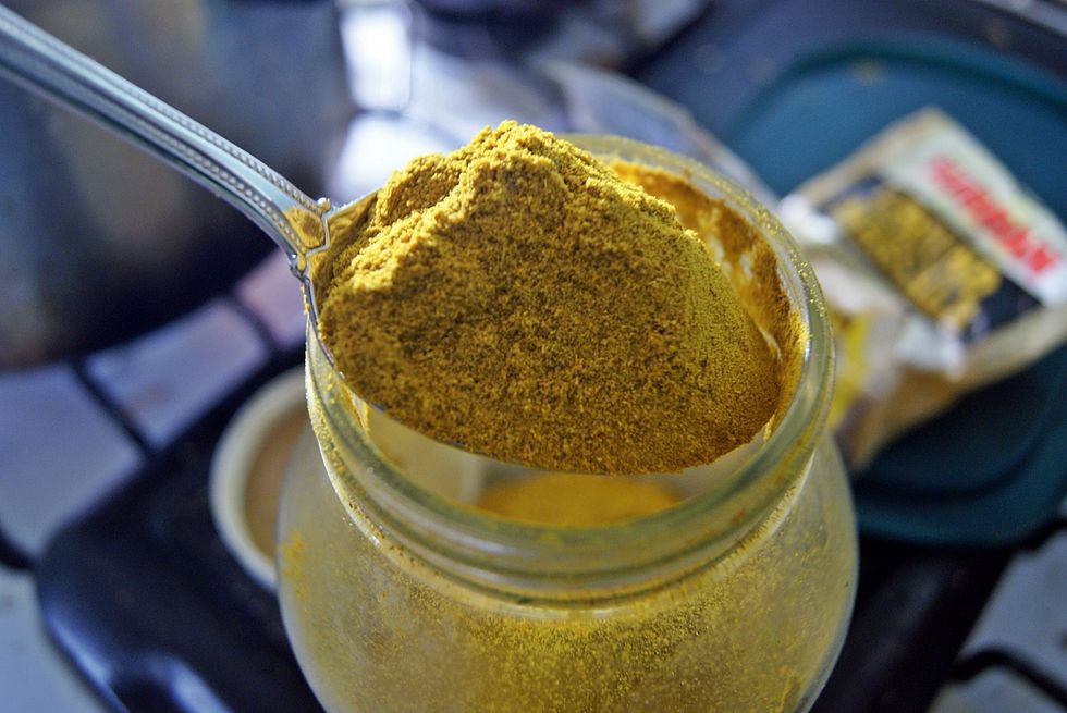 Take the burnt garlic out of the oil. No pics of this because at this point the oil is hot, so you have to move quickly. Get a very heaping spoonful of curry powder...