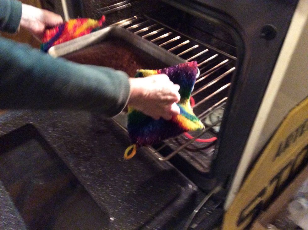 Take the cake out take oven mitts or pot holders and take the rack out and the cake out then turn the oven off wait to touch the cake it will be hot wait about a halfhour if you want to frost it