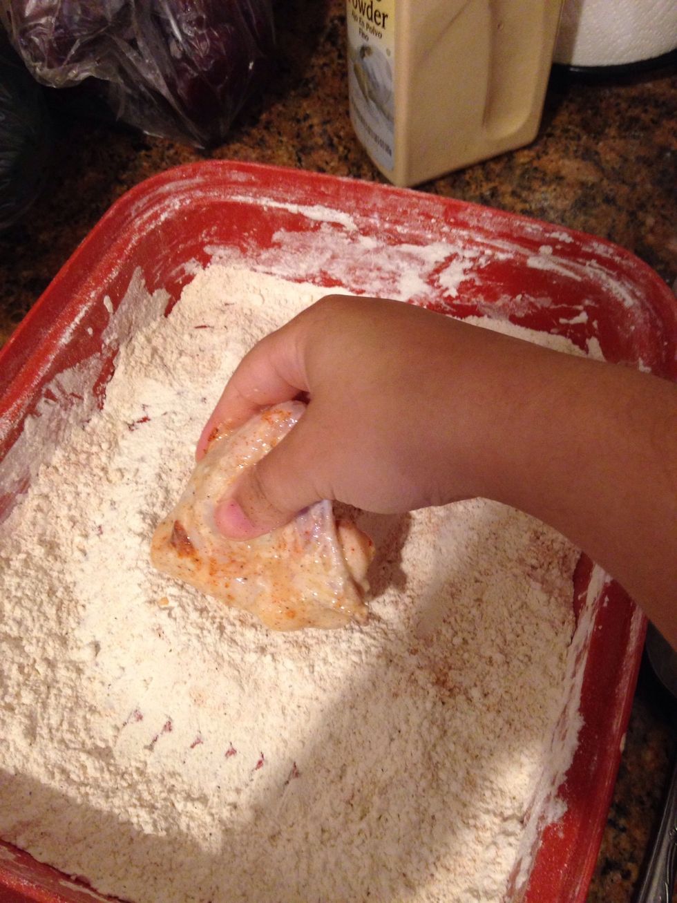 Take the chicken and place in the heavily seasoned flour. Make sure to mix up the flour so that it's an even mix of seasoning.