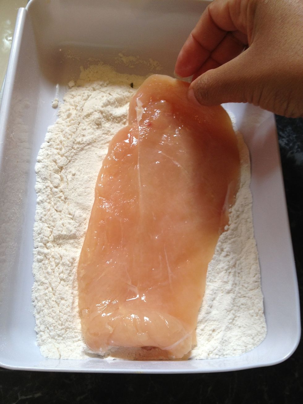 Take the chicken pieces and dredge it in flour