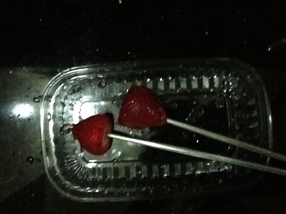Take the chopsticks and poke them into the strawberry to keep the strawberries in place
