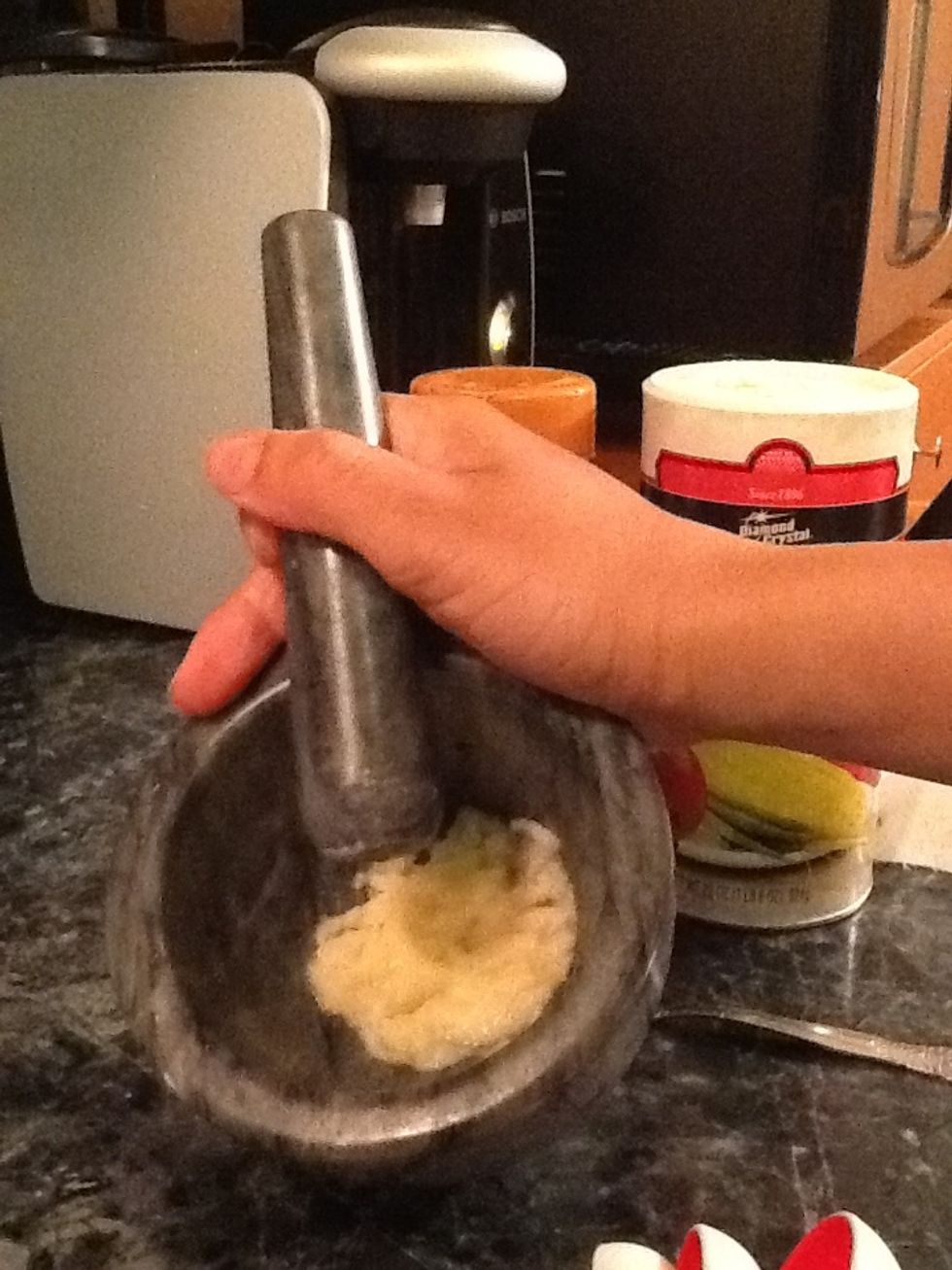 Take the cloves and put it Into a mortar and start pounding away. We want to get the cloves to the consistency of paste,like mine. If you don't have a mortar a fine grater is fine
