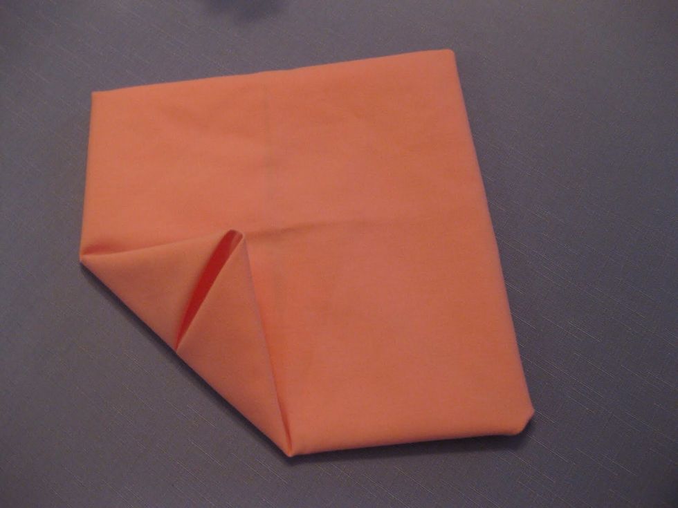 Take the corner of the napkin and fold to the center once again.