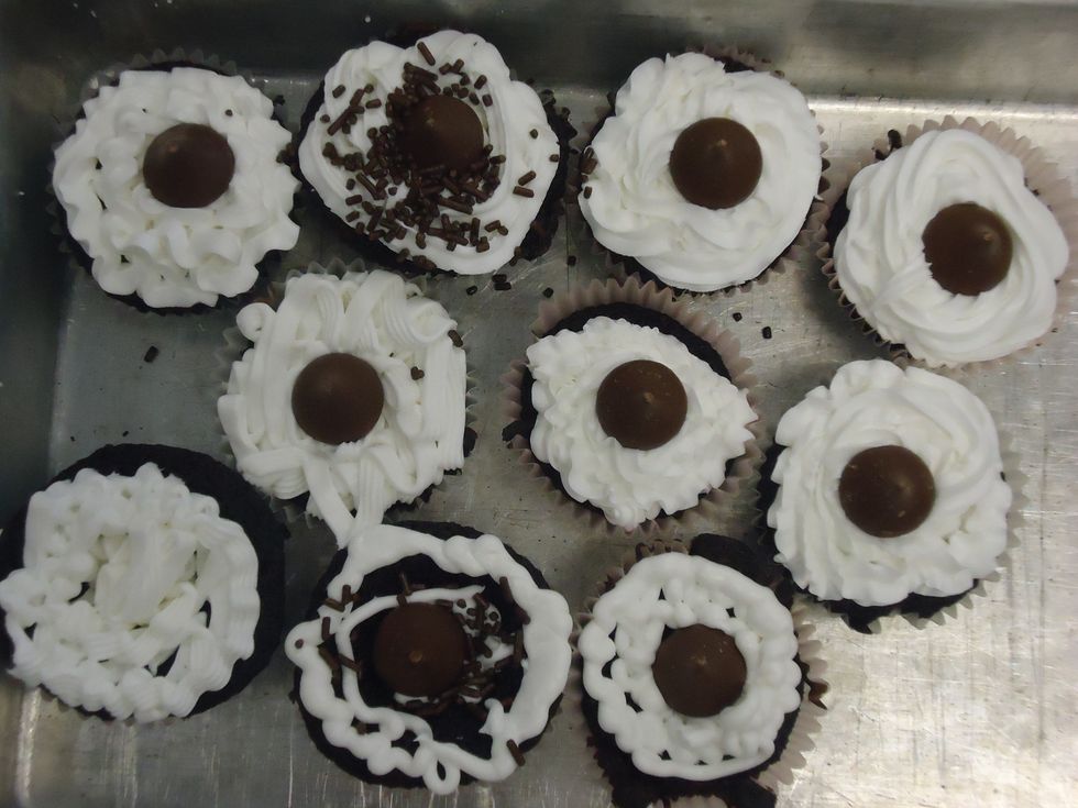 Take the cupcakes out of the oven. Wait 20 minutes and then put the frosting and sprinkles on. Optional: Put a chocolate hershey's kiss on top of the cupcake.