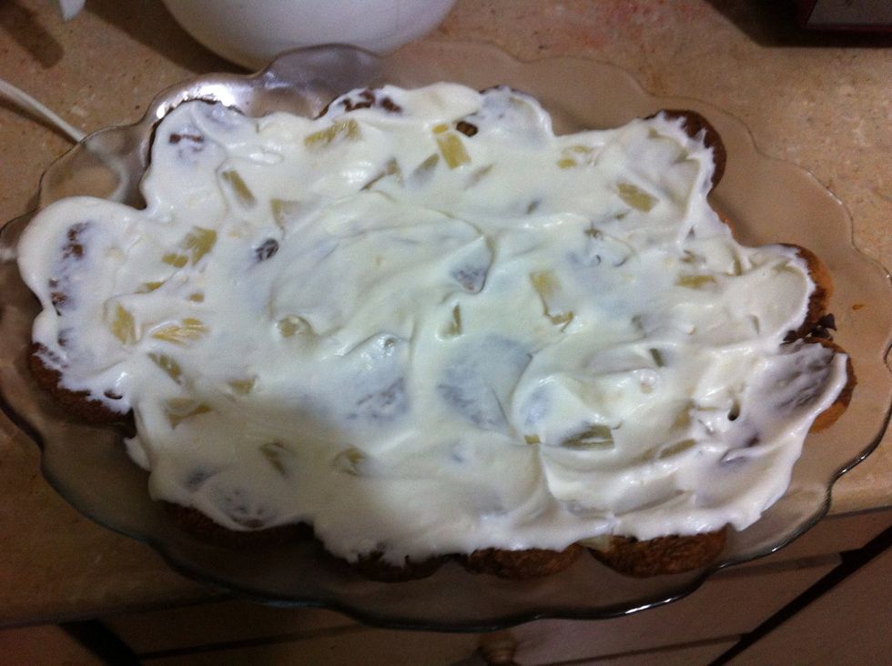 Take the dish out, spread cream cheese, sprinkle pineapples on this first cookie layer. You can see the chunks of pineapple there