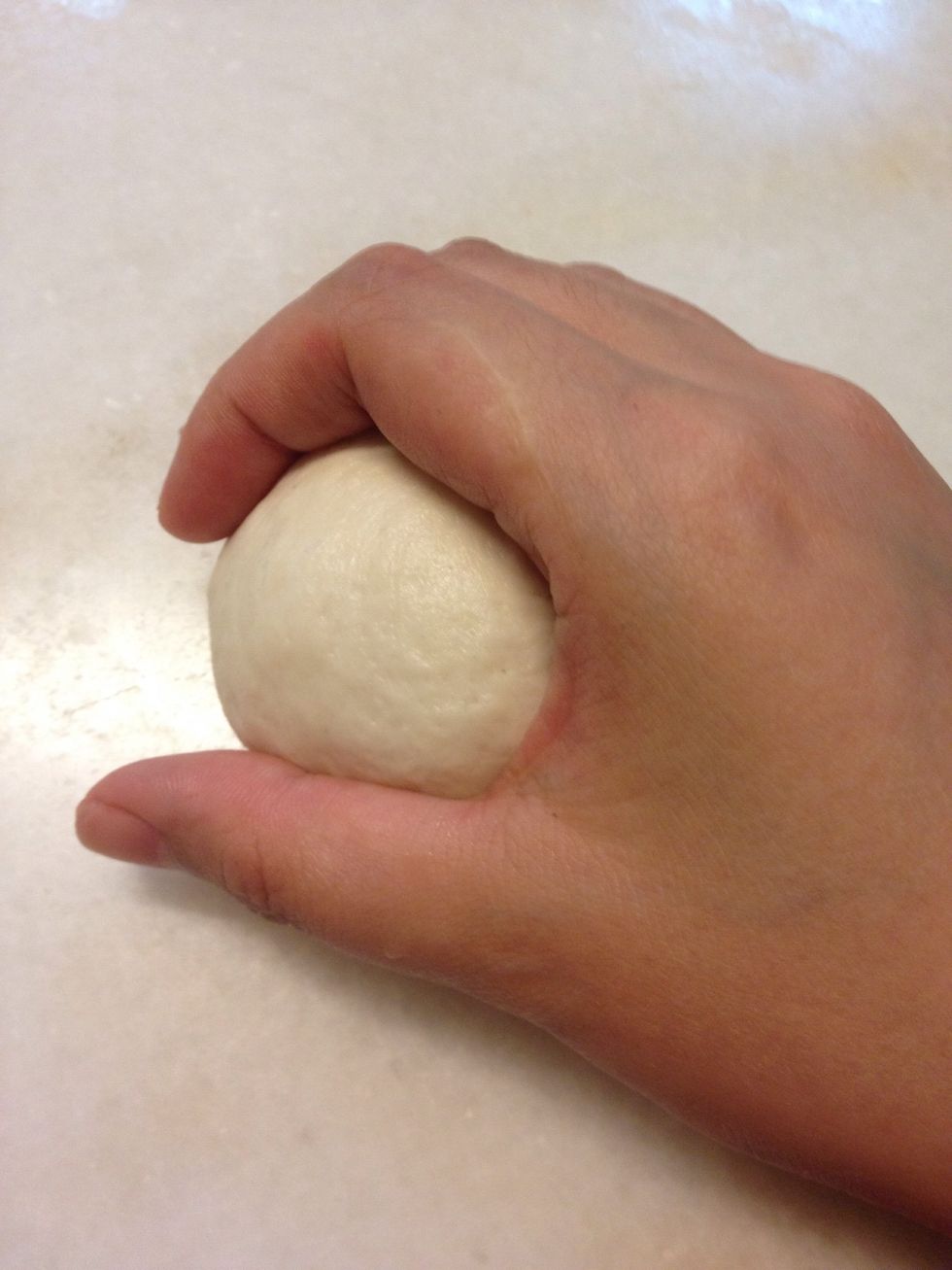 Take the dough and press gently against the countertop moving your hand in a circular motion until a dough ball is formed.