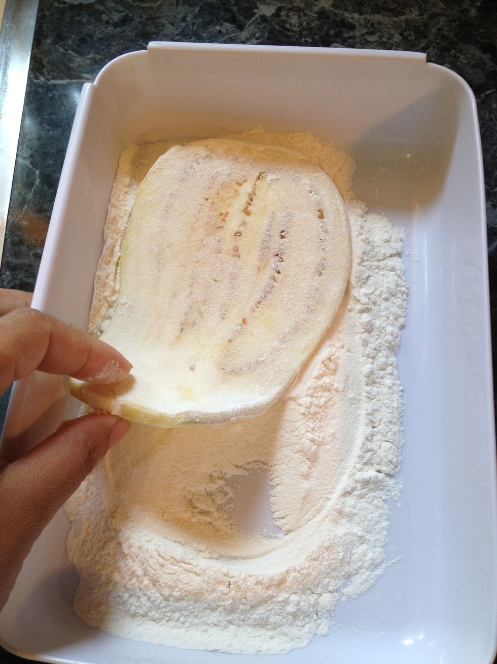 Take the eggplant piece and dredge it in the flour first