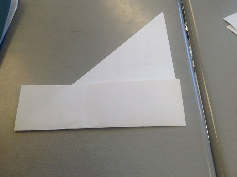 Take the extra paper and fold it along the bottom of the folded triangle and resold it on the other side