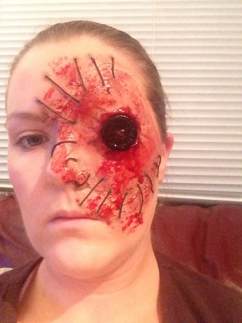 Take the fake blood on a sponge or some tissue paper and dotted it a bit around your face,