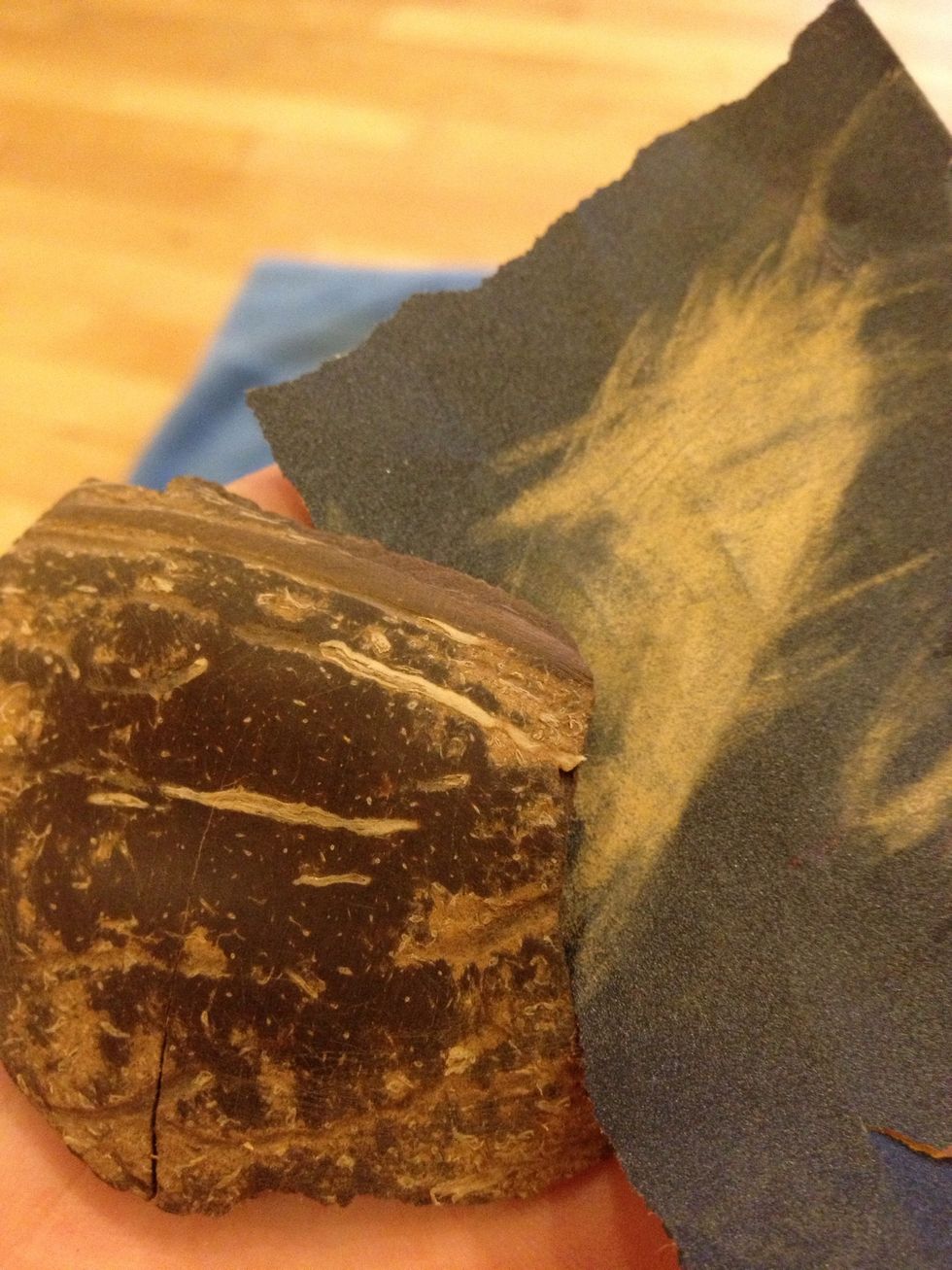 Take the finest grit sandpaper you have and go over the front until it looks polished. Don't worry about the light colored lines - they make the final pendant look interesting.