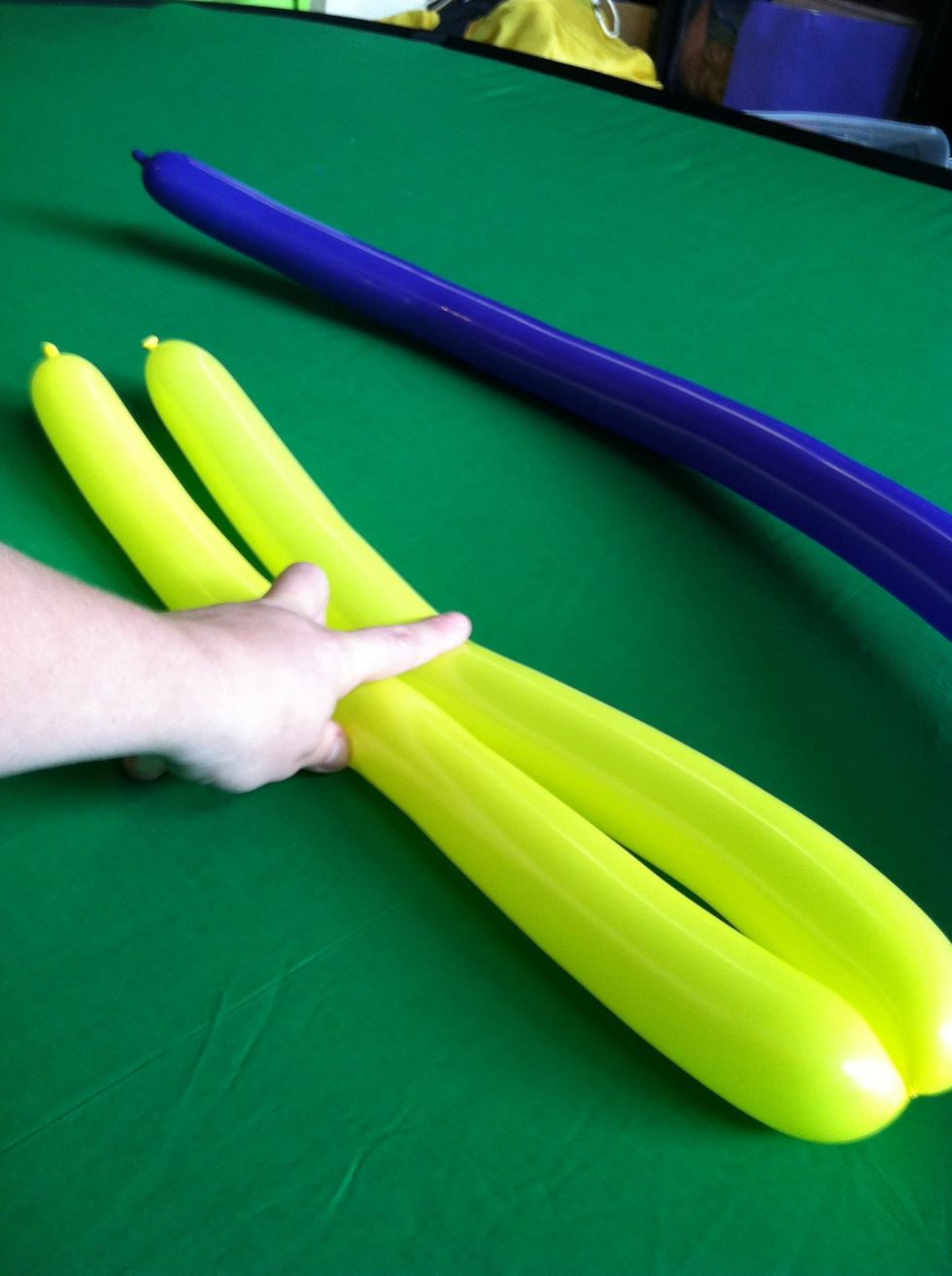 Take the first balloon, fold in in half, and put a twist in the middle