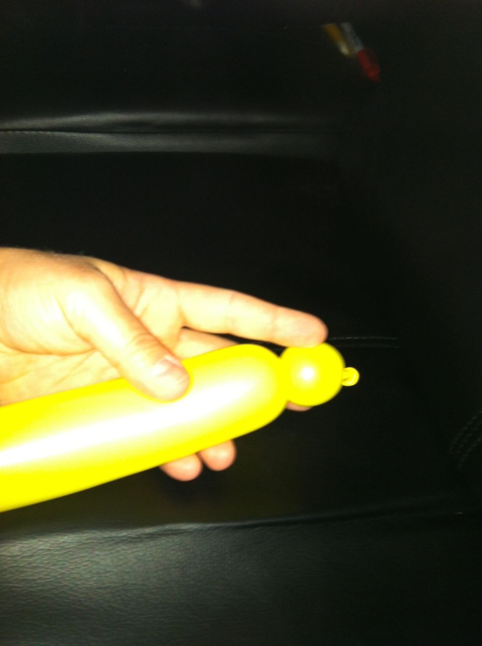 Take the first yellow balloon and make a small bubble. Hold onto that bubble while you do the same to a second yellow balloon