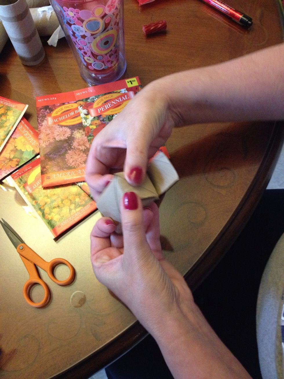 Take the four flaps and fold them in to make a bottom.