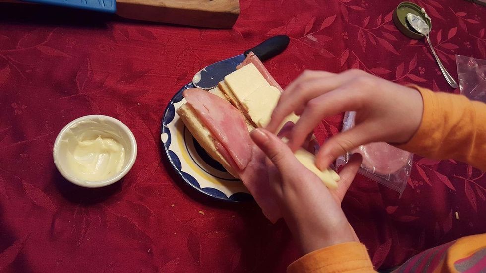 take the four pieces of deli ham an place two pieces on each side.then take the five slices of cheese an lay them on only one side of the bread.