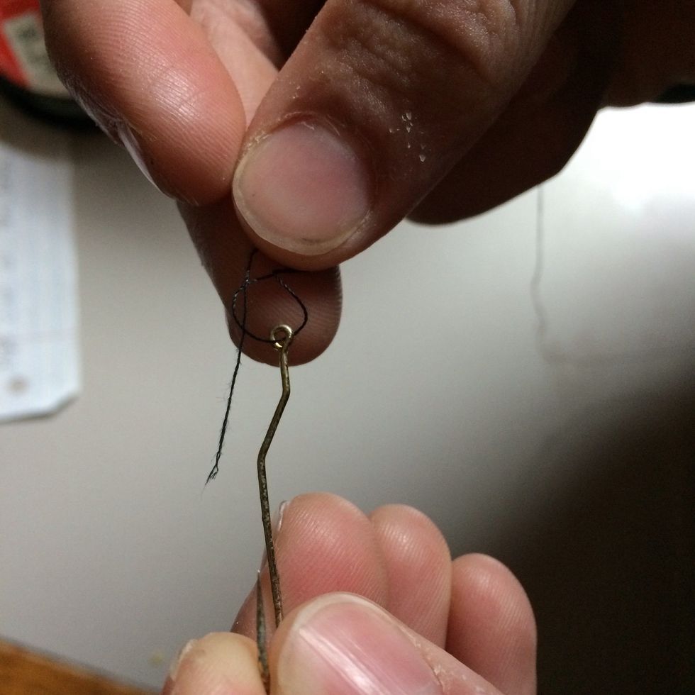 Take the free end of the line in your right hand and feed it through the loop made closest to the eye of the hook