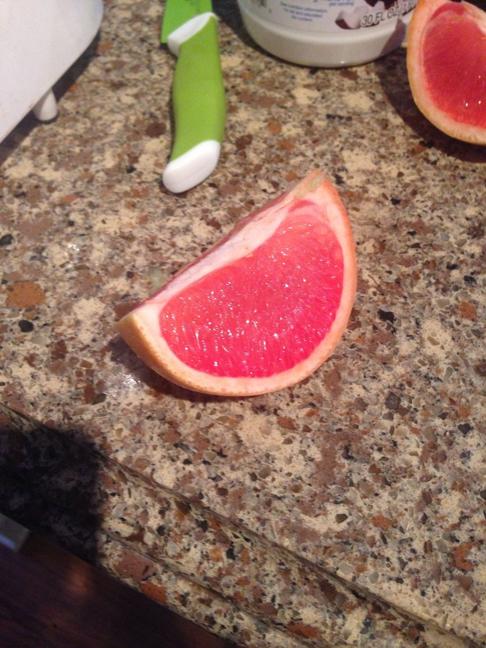 Take the half of grapefruit and peel it. You could cut it into smaller pieces if you wanted but you don't have to.