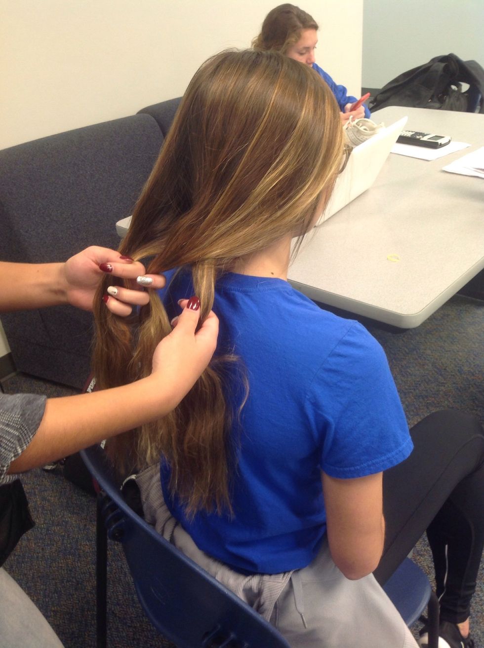 Take the hand with two pieces and put the outside piece over the top of the middle piece. Now, you should have two pieces in the opposite hand.