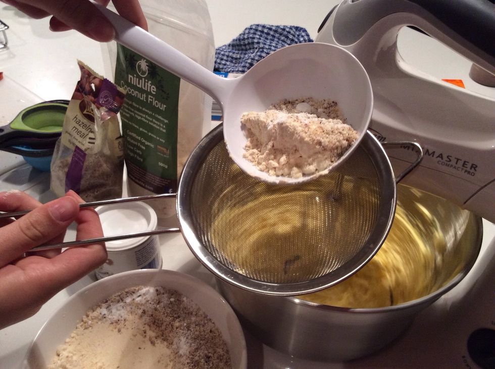 take the hazelnut, coconut, baking powder mix and sieve it into the now well mixed butter mix.