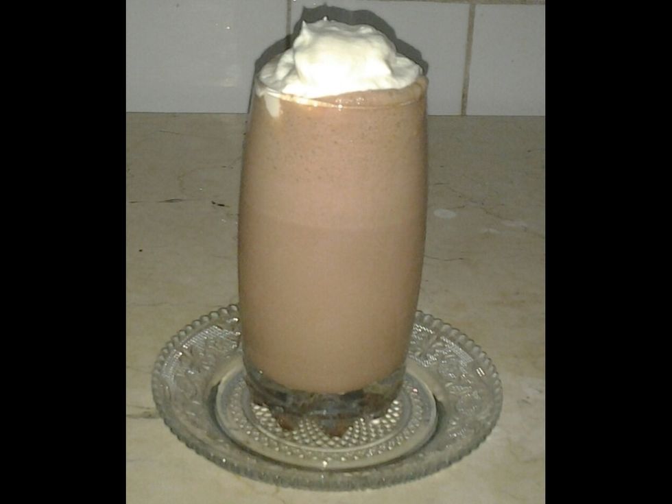 Take the iced chocolate out of the fridge and slowly spread out two tablespoons of rich whipped cream on the surface of the divine iced chocolate.
