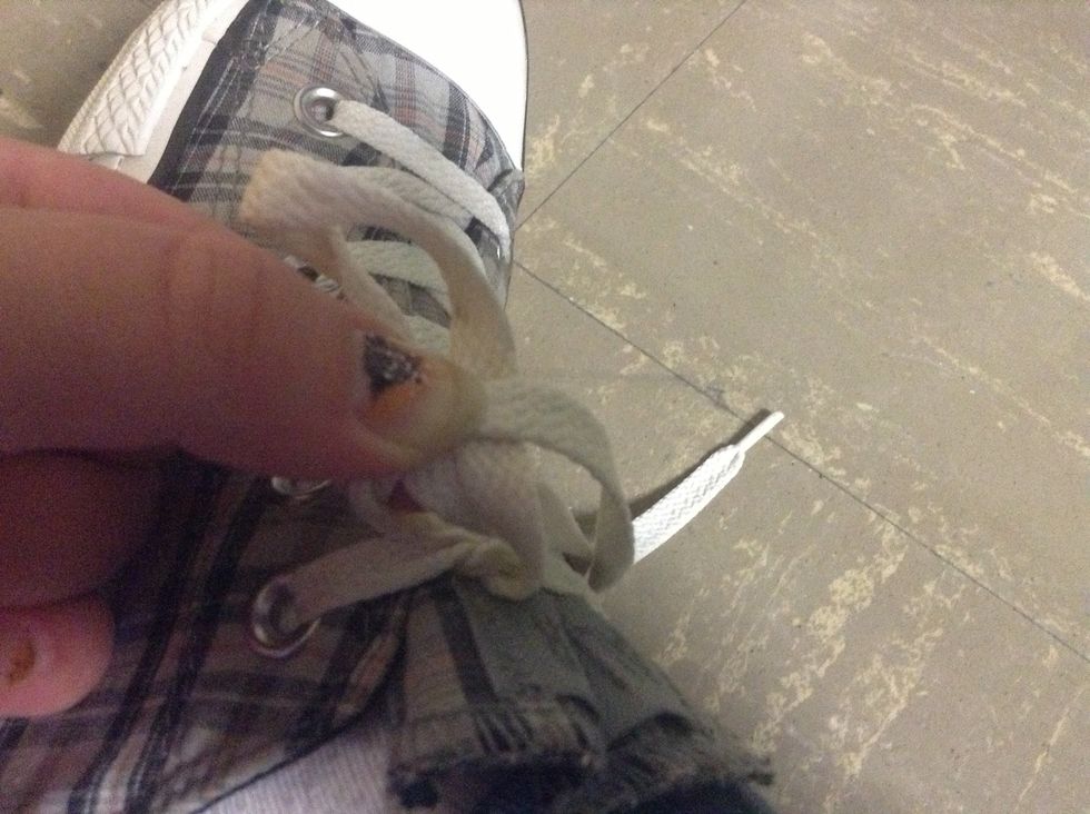 Take the left lace and put it over the loop like so.