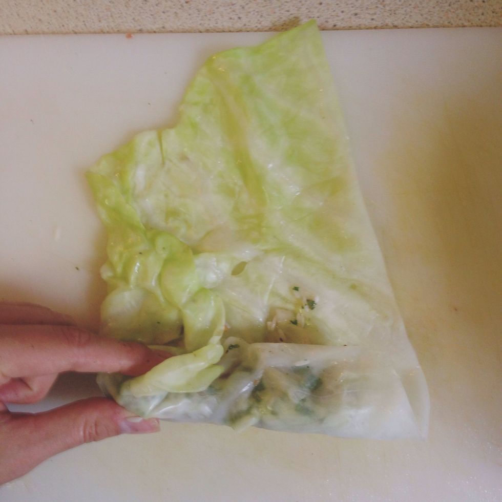 Take the left side of the cabbage leaf and flip it over to ensure the left side of the cabbage roll is "closed." Roll the rest of the cabbage from bottom to top and place in pot.