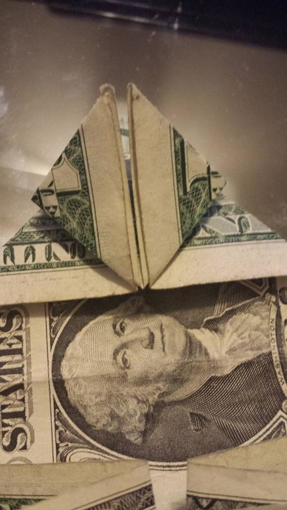 Take the left top layer and fold it to the middle of the big triangle.