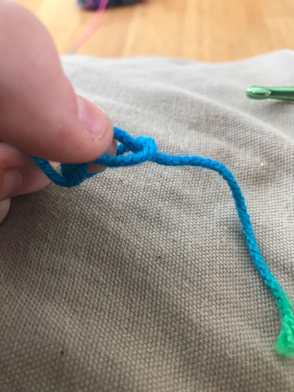 Take the little tail and put it through the loop