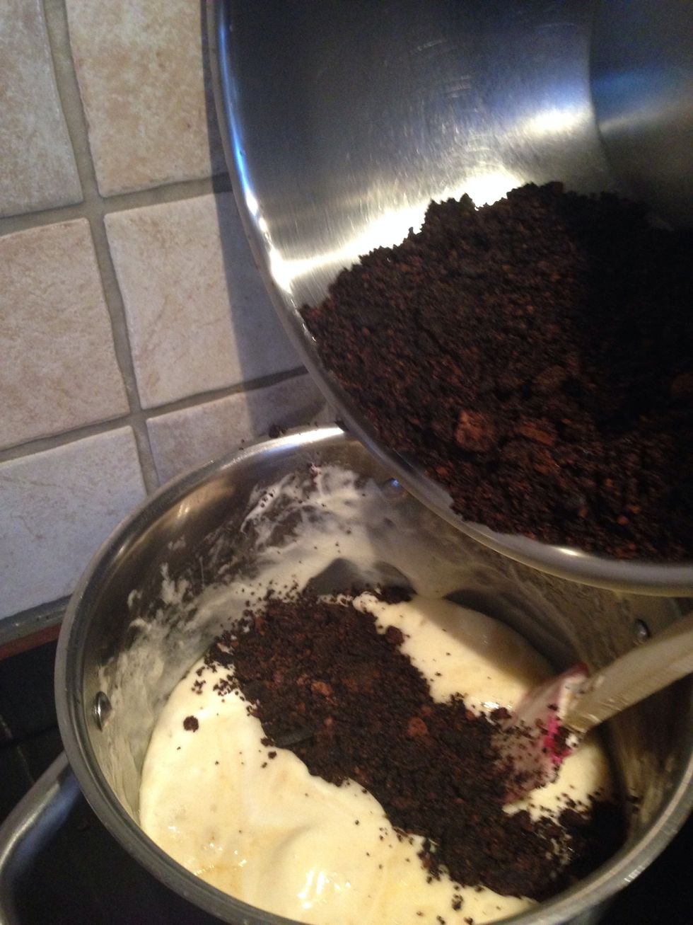 Take the marshmallow mix off the heat and add in the crushed Oreos, and stir right away. This gets sticky, but keep on stirring it until it's mixed completely