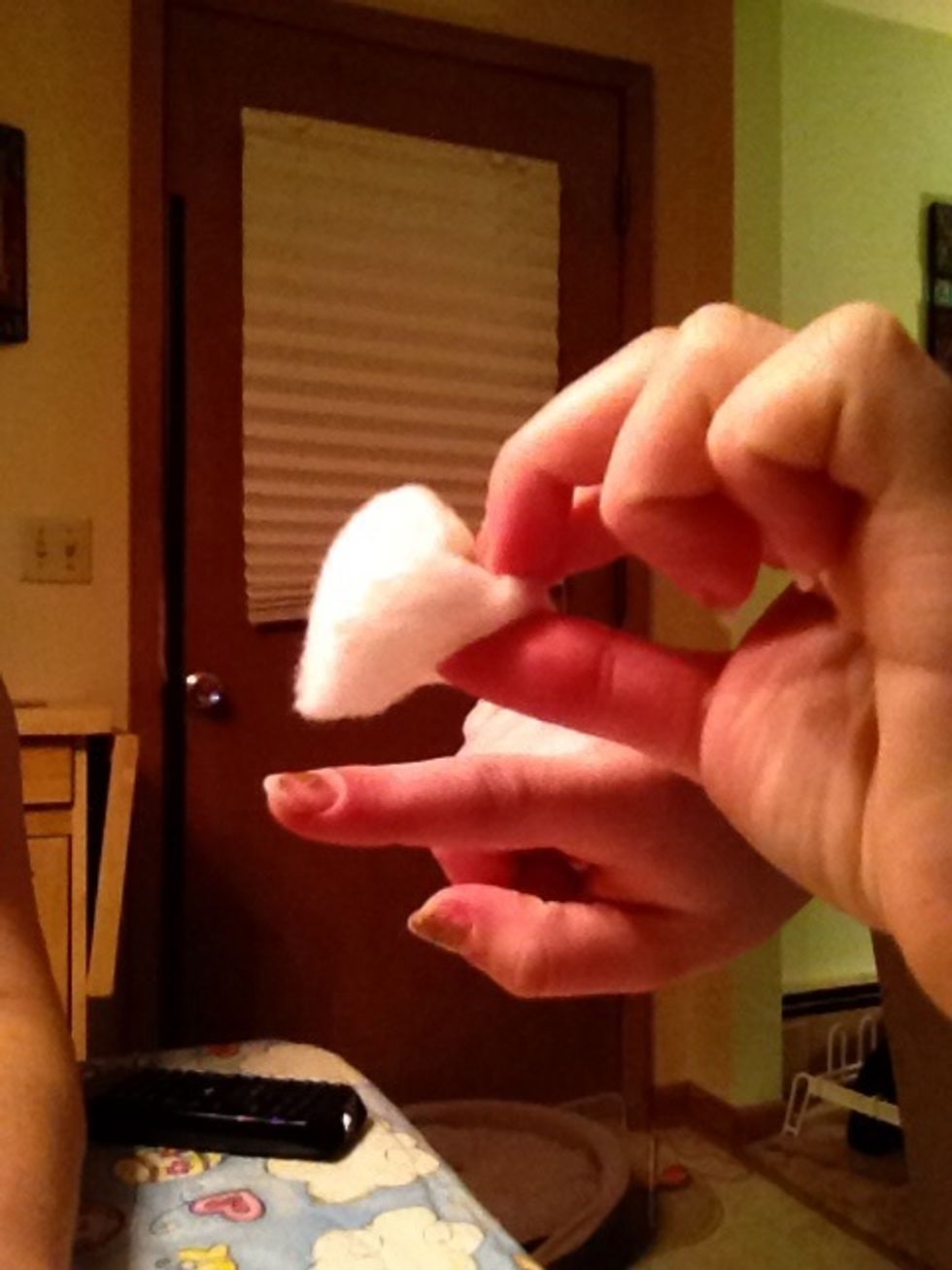 Take the nail polish remover filled cotton ball and apply it to your nail that has nail polish on it. Lightly rub the nail with the ball so that it removes the nail polish.