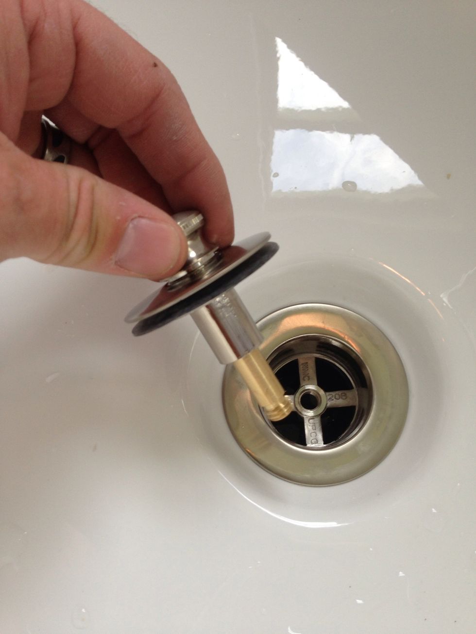Take the new stopper and screw it into the center hole in the drain. Rotate the stopper clockwise