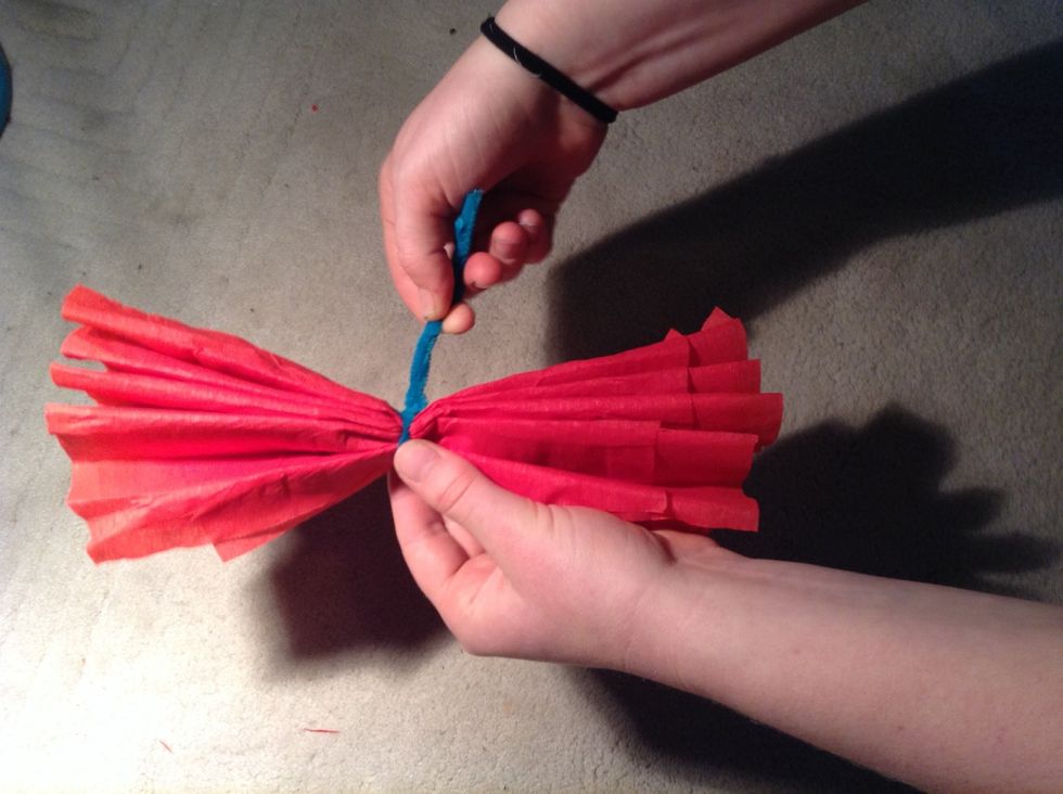 Take the pipe cleaner or wire and wrap it tightly around the centre, securing it with a simple knot. Twist the excess wire strands together (this will create the stem of your flower).