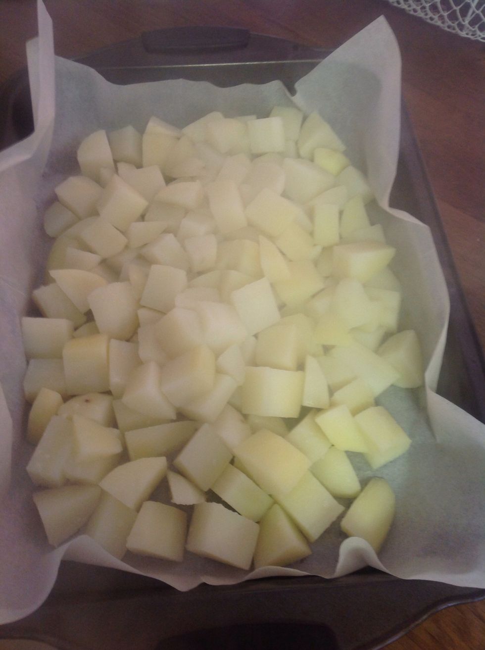 Take the potatoes out of the water and put them in a baking dish with baking paper