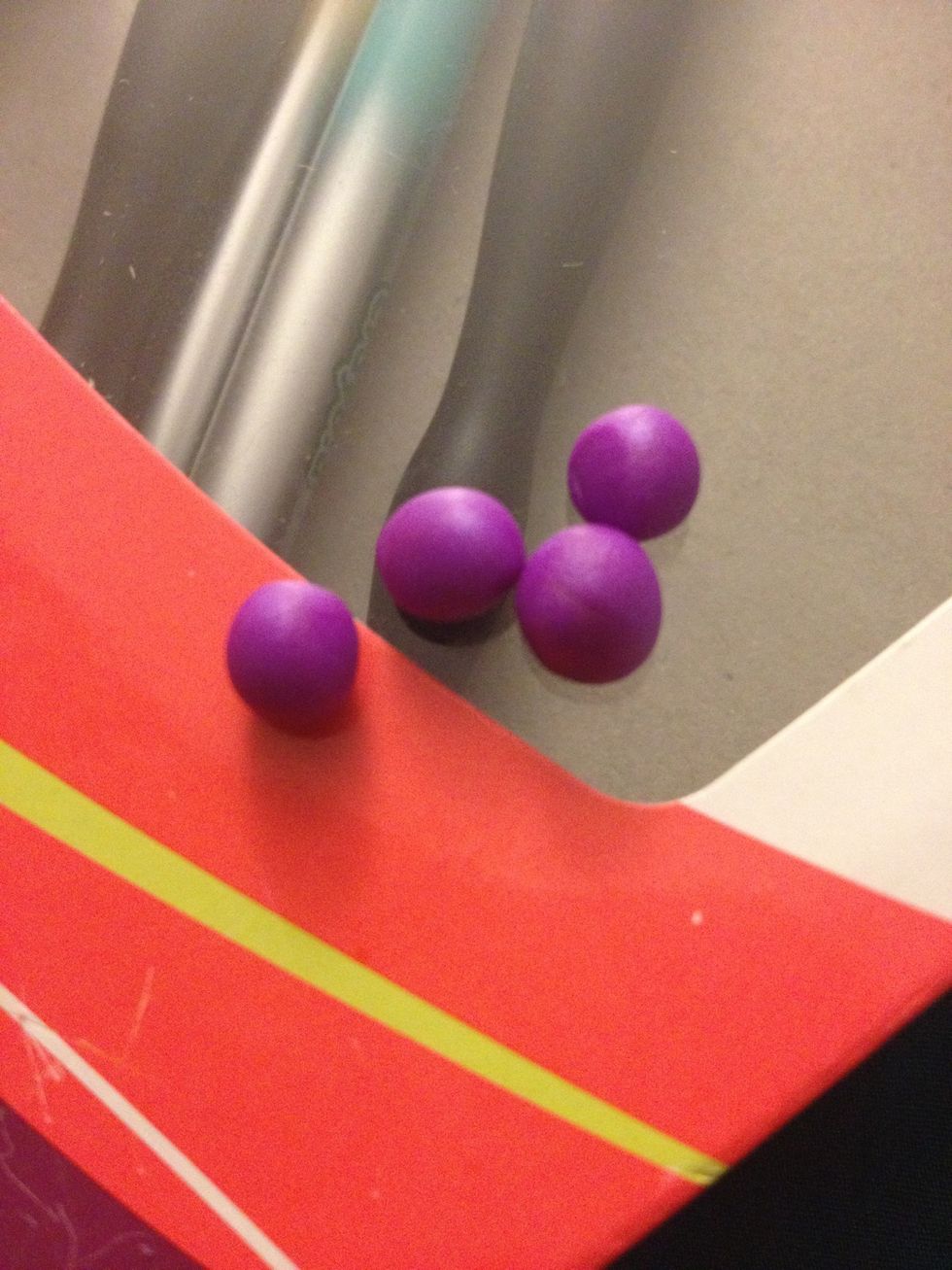 Take the purple and cut it into four different parts. Make them into spheres.