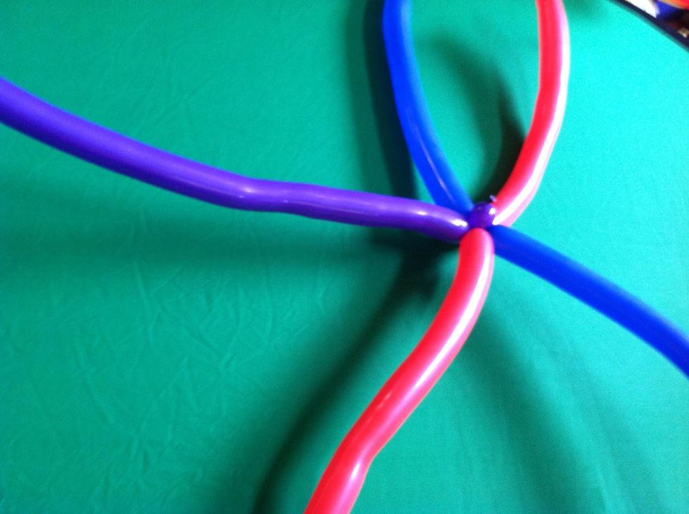 Take the remaining balloon and twist a small bubble at the end and attach it to the center of the x