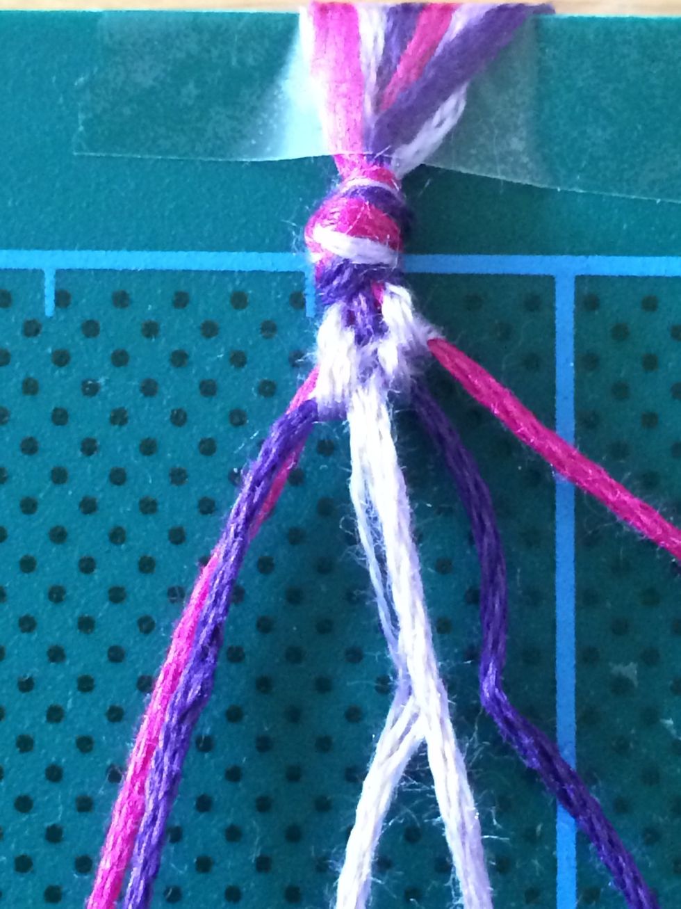 Take the right lilac thread and make a knot over the left lilac thread, repeat to create a double knot.