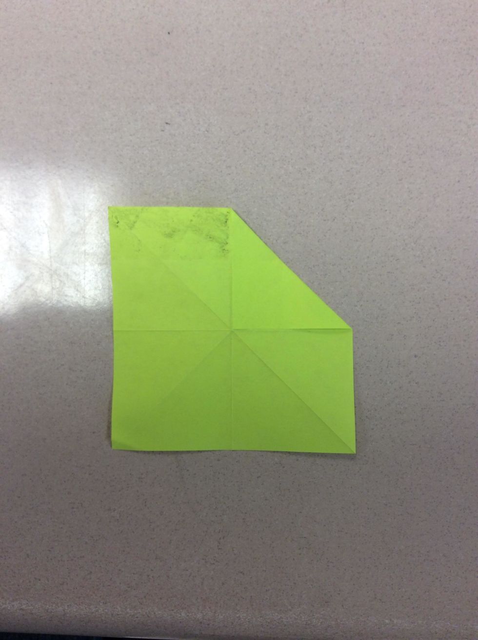 Take the right top corner and fold it to the center. It should look like the picture.