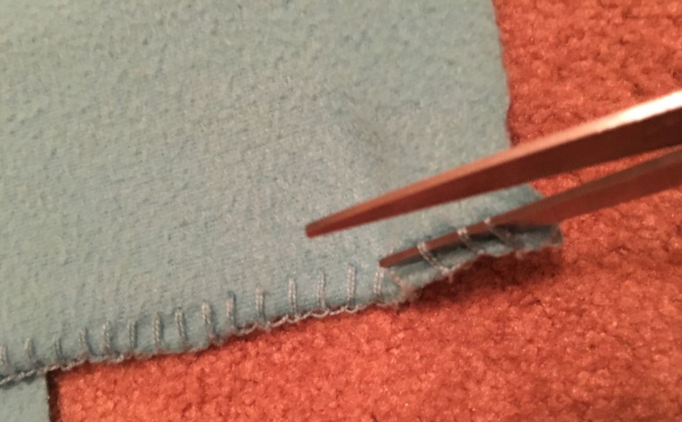 Take the scissors, and remove all the outer seems. Once you get it started, you should be able to just pull on a string and the rest should come out easily with no scissors.