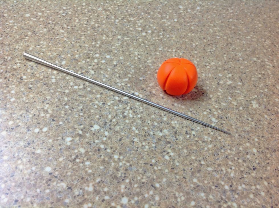 Take the sculpting tool and press it vertically along the outside of the ball to give it pumpkin-like grooves. Make as many grooves as you desire, but spread them out to make the pumpkin realistic.