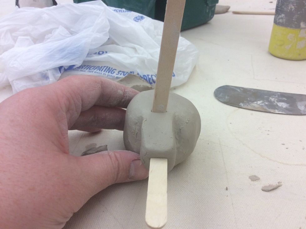 Take the second Popsicle stick and create a square directly on top of the first Popsicle stick.