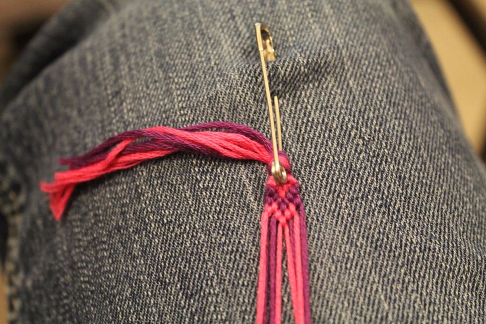 Take the second string in on the left side and tie a backward knot around the outside string on the left, going left.