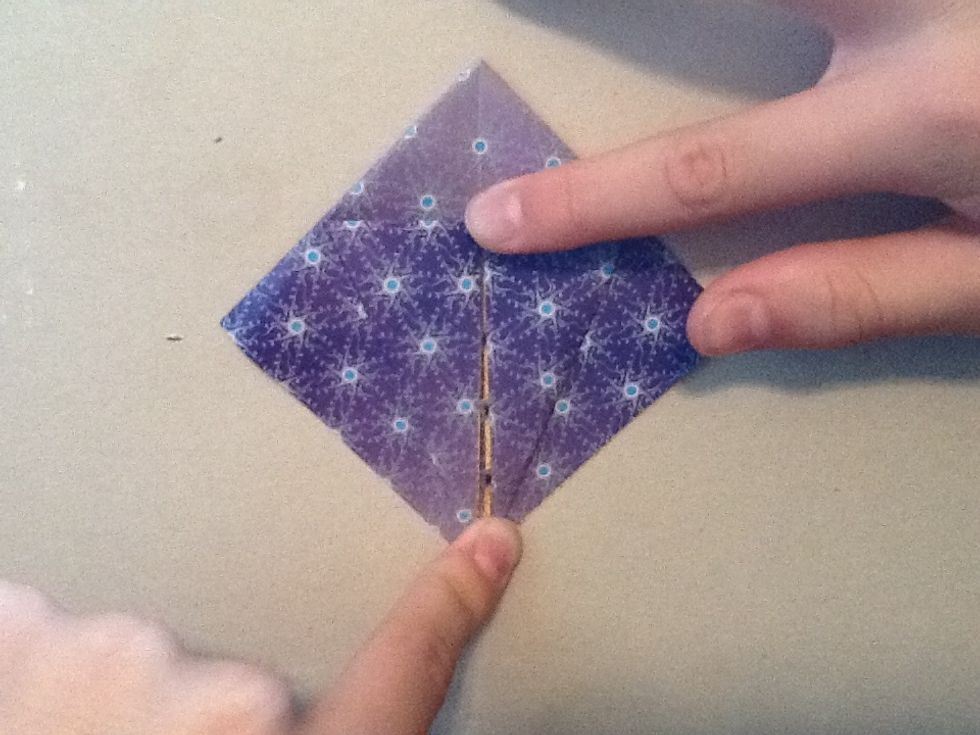 Take the side of the square and fold it in to the middle and to make a triangle shape. Do the same to the other side.Turn it over and do the same. When done it should look like a kite.