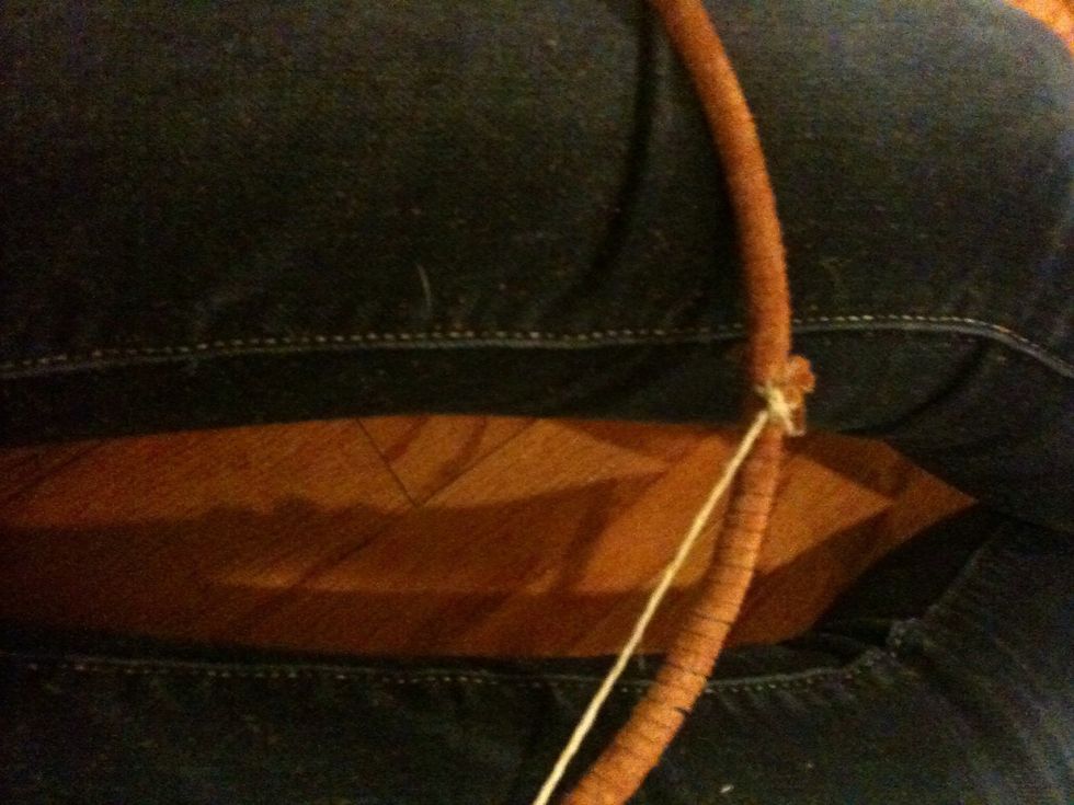 Take the sinew and place it over the leather.