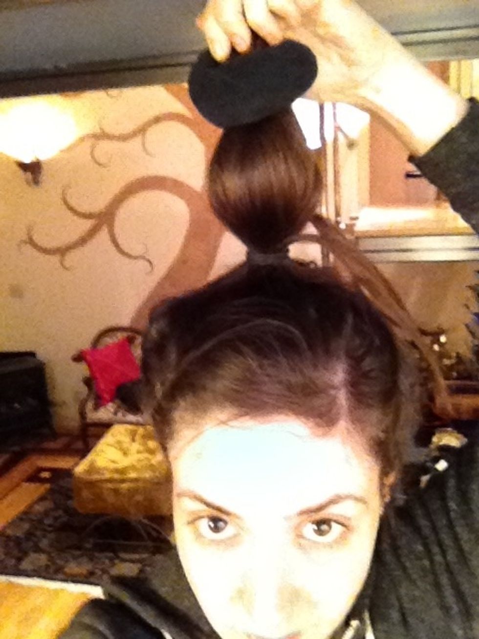 Take the sock donut and loop it through the ponytail.