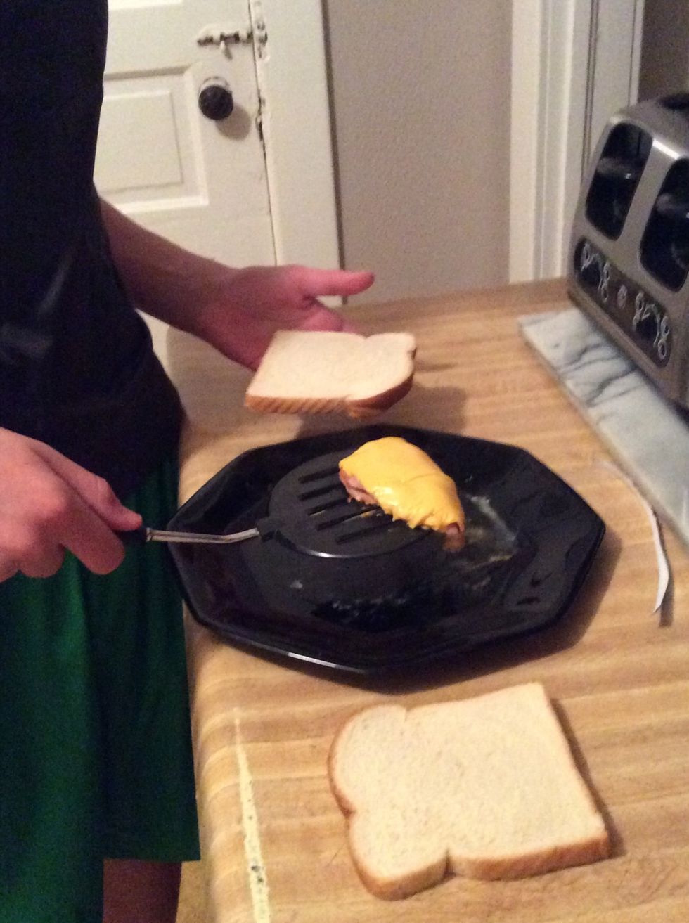 Take the spatula and lift up tye ham and cheese and put the bread down and lower it on to the bread so the ham and cheese is symmetrical